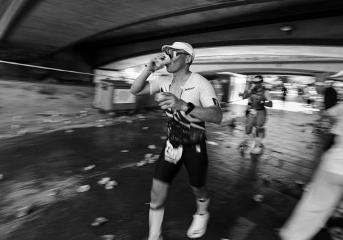 Runner drinks from cup during a race.