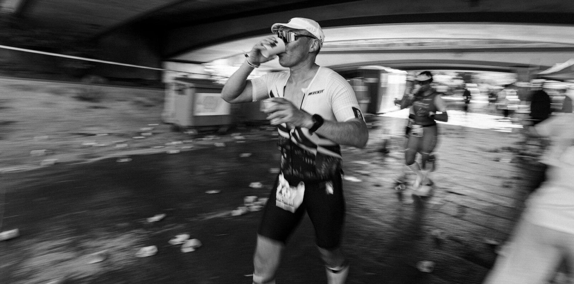 Runner drinks from cup during a race.